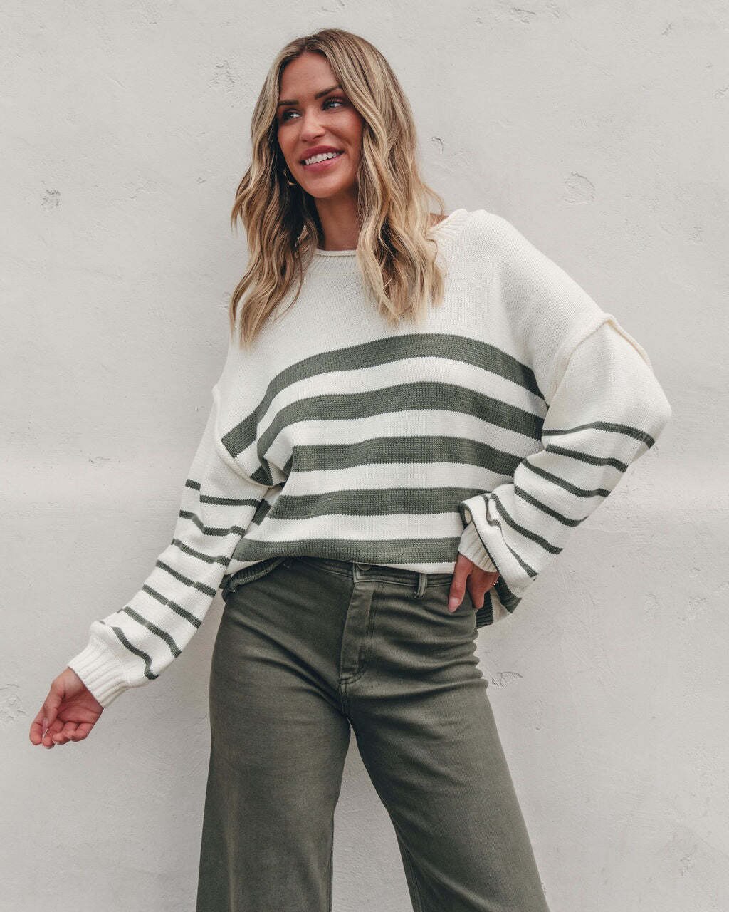 Hayley is wearing our Olive and Cream Striped Pullover Sweater with olive jeans.