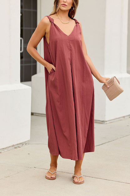 Woman in the Audrey Knot Strap Midi Dress - Burgundy, holding a woven bag—a comfy, bump-friendly look for any occasion.