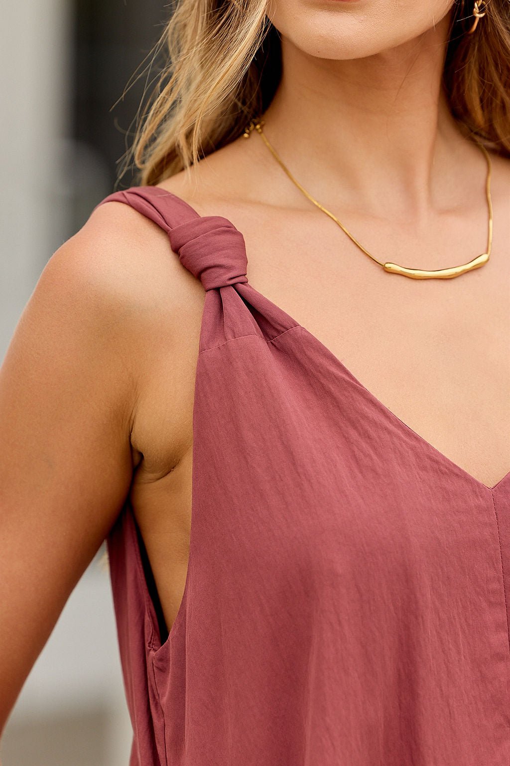Woman in a burgundy Audrey Knot Strap Midi Dress, bump-friendly with knotted straps, styled with a gold necklace.