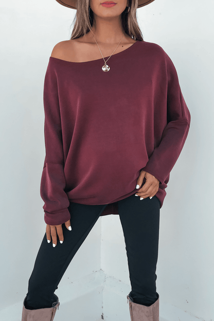 Woman in a Burgundy Soft Cloud Scuba Pullover, black pants, taupe boots, and hat stands against a white background. Made in USA.