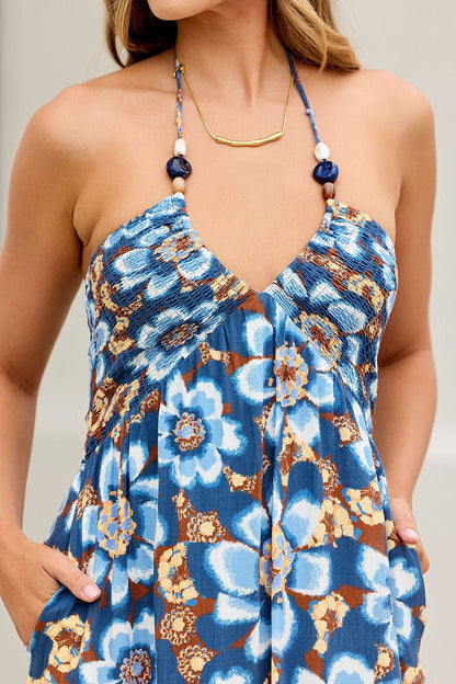Woman in Catalina Halter Midi Dress - Navy, hands in pockets, gold necklace with blue accents.
