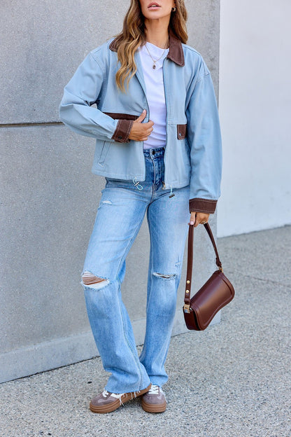 Woman in a Contrast Trim Jacket - Dusty Blue, white shirt, ripped jeans, brown shoes, and brown handbag outside.
