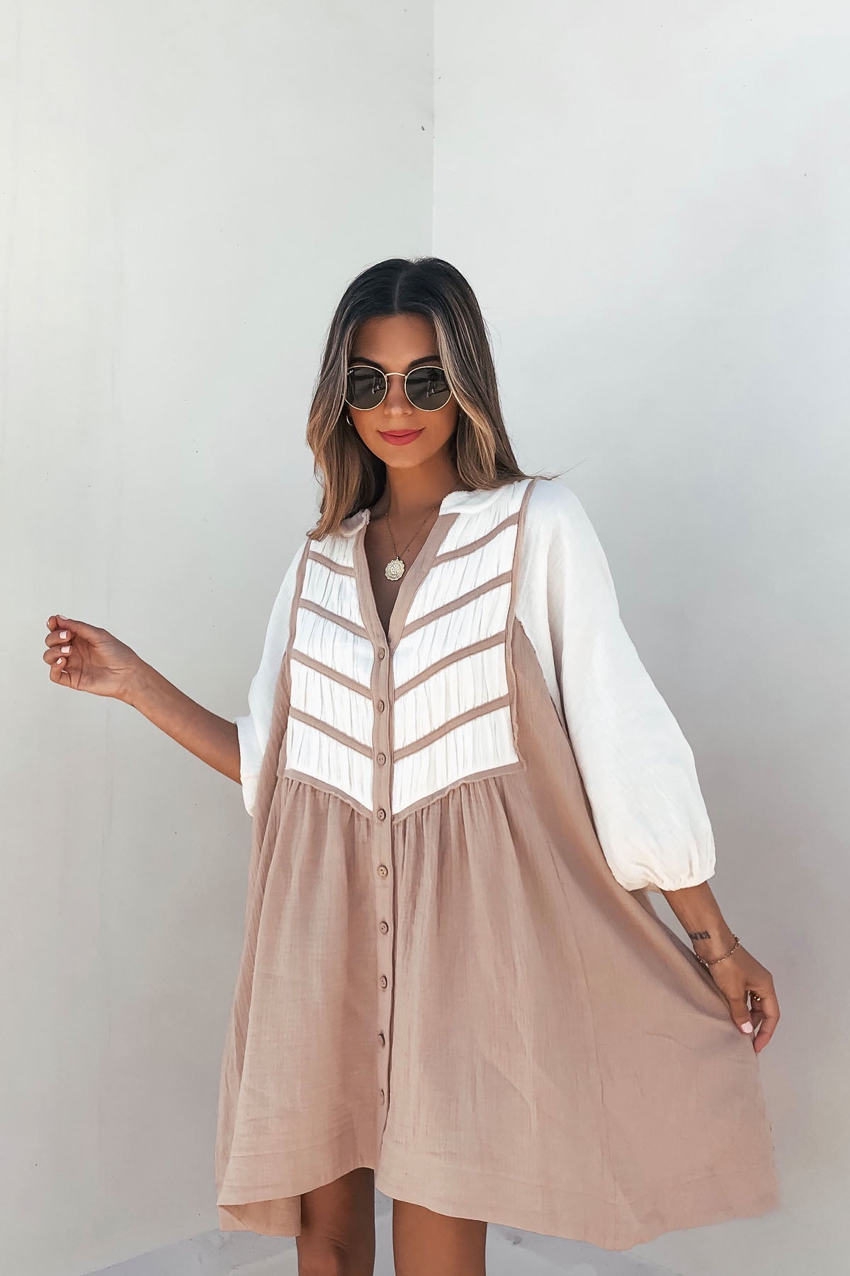 Woman in Cream Color Block Tunic Dress-FINAL SALE, sunglasses, and red lipstick stands against a plain light background.