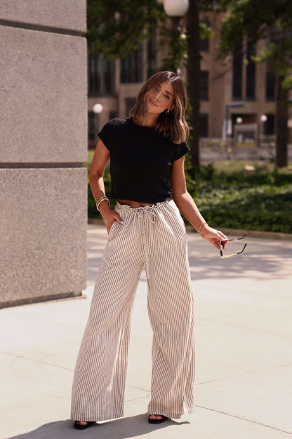 Woman in the Everyday Essential Black Tee-FINAL SALE enjoys 100% cotton softness and a comfortable fit outside.