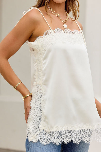 Woman wears the Lace Dream Cami Tank Top - Ivory-FINALSALE with jeans and gold jewelry while standing outdoors.