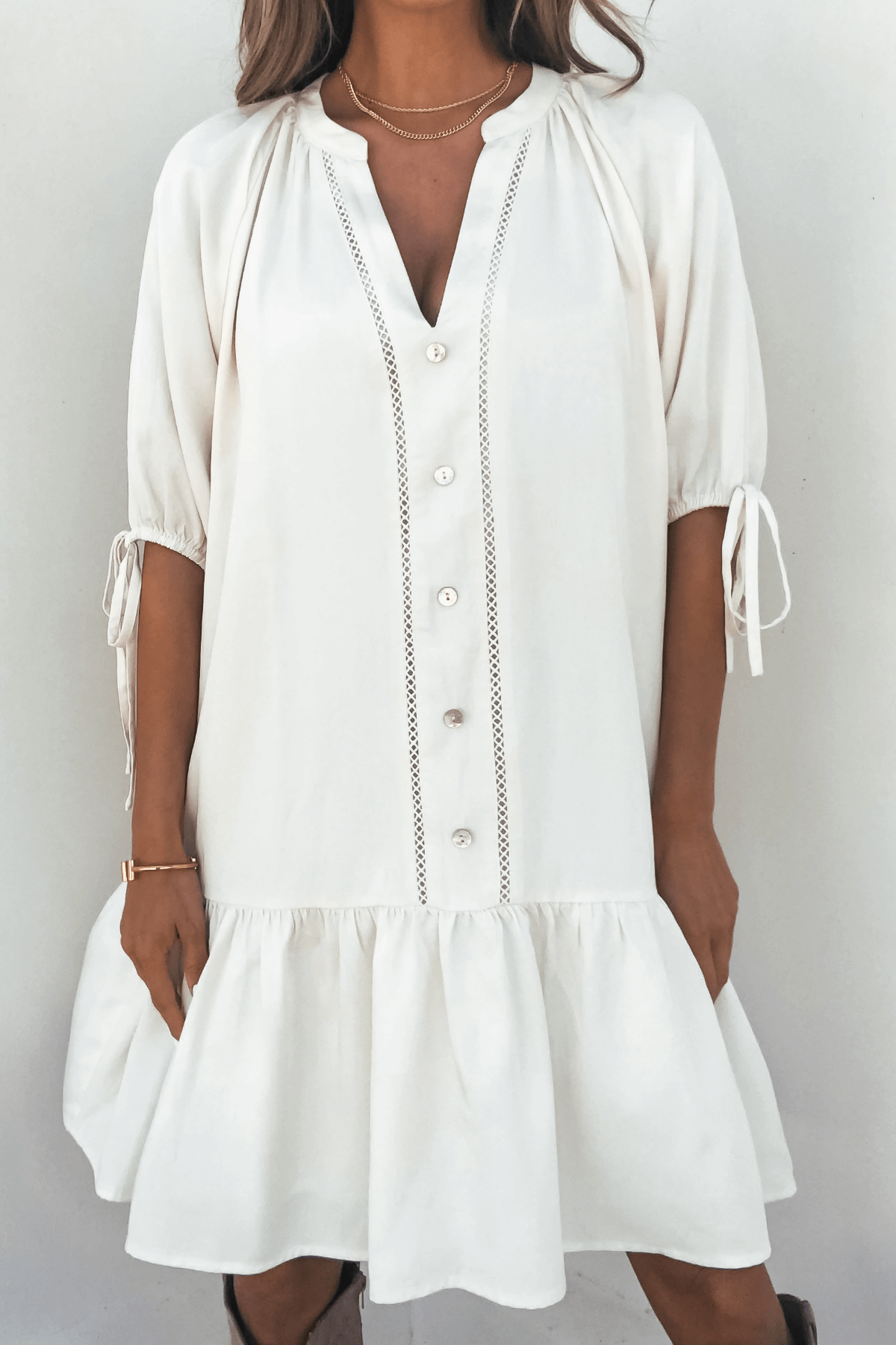 Woman in the Laurie Cream Button Down Mini Dress stands against a plain background.