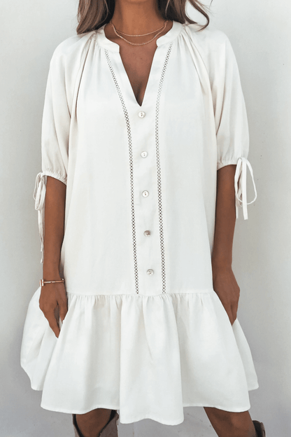 Woman in the Laurie Cream Button Down Mini Dress stands against a plain background.