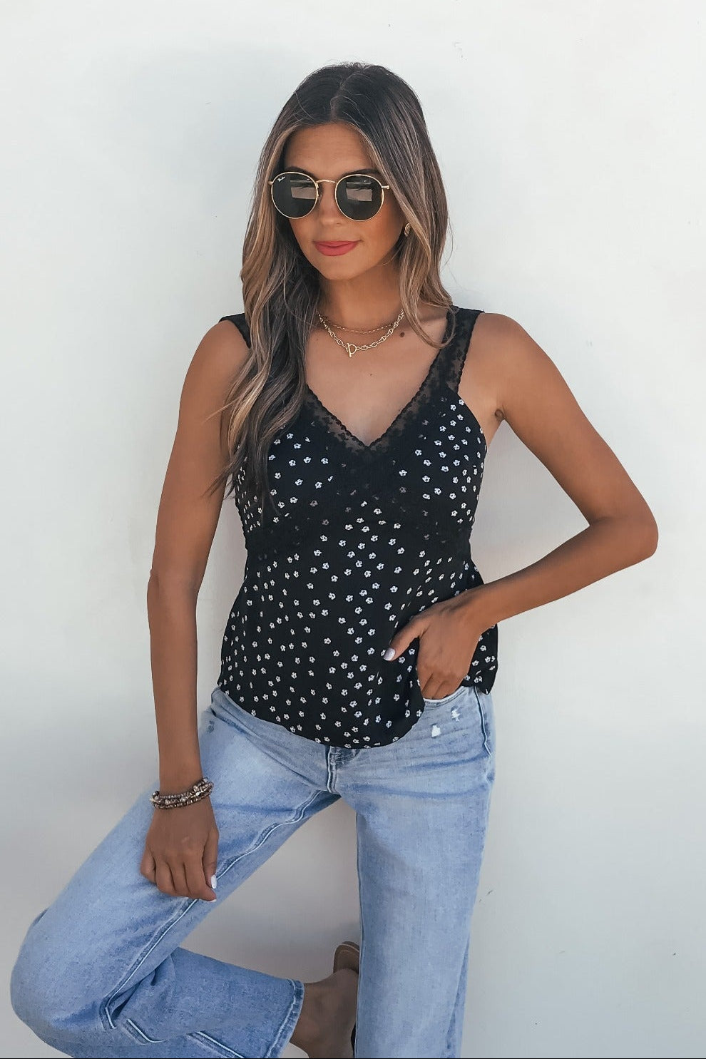 Woman in sunglasses wears the Midnight Lace Print Tank Top - Black, styled with light blue jeans against a white background.