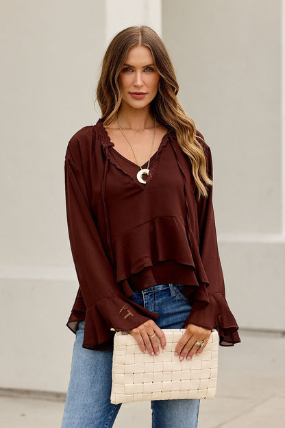 Woman in the Office Bell Sleeve Top - Brown, styled effortlessly for work to weekend, holding a woven clutch against a light backdrop.
