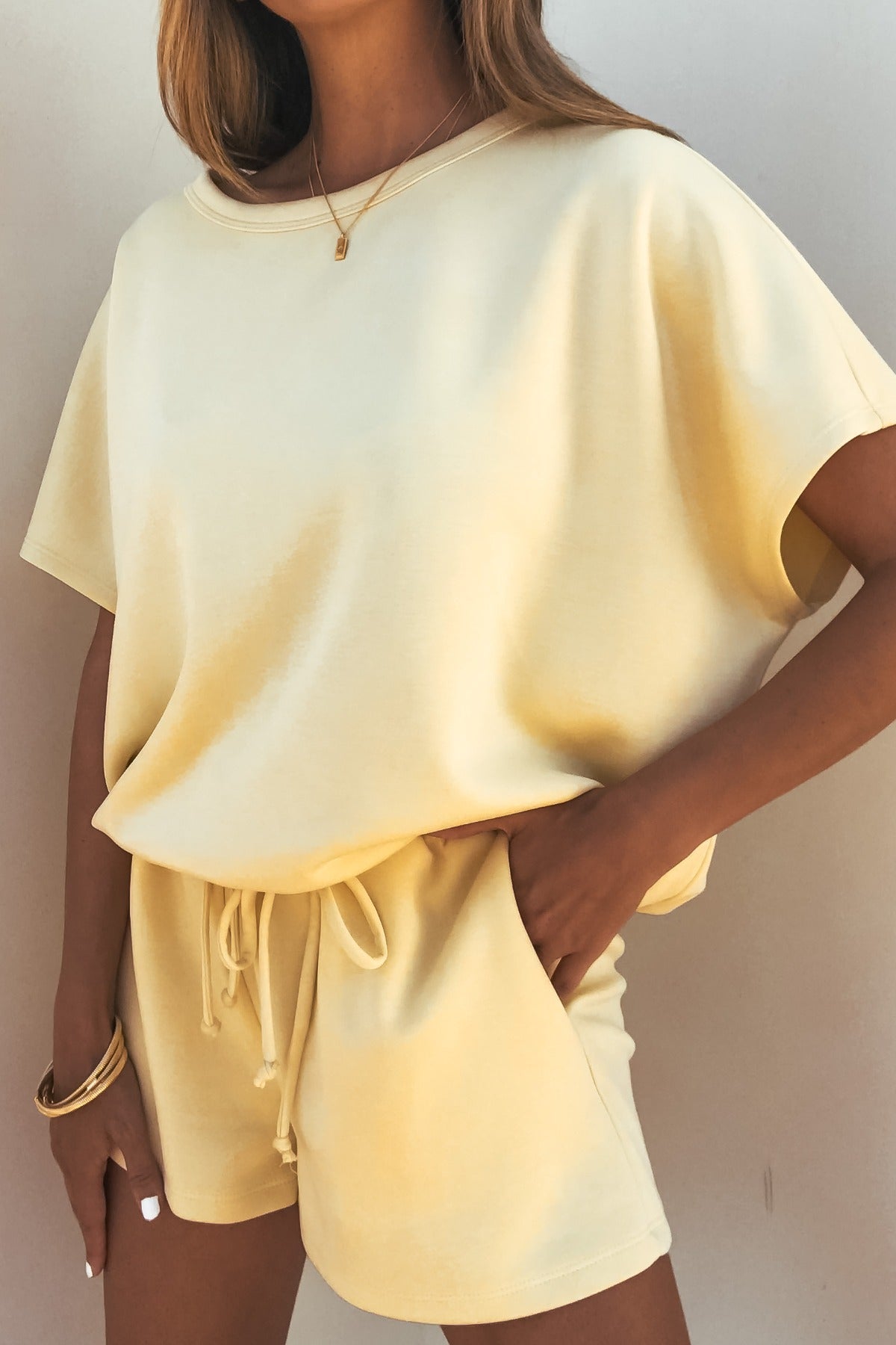 Woman wearing the Soft Cloud Scuba Lounge Top in yellow, styled with matching shorts; stretchy and relaxed fit.