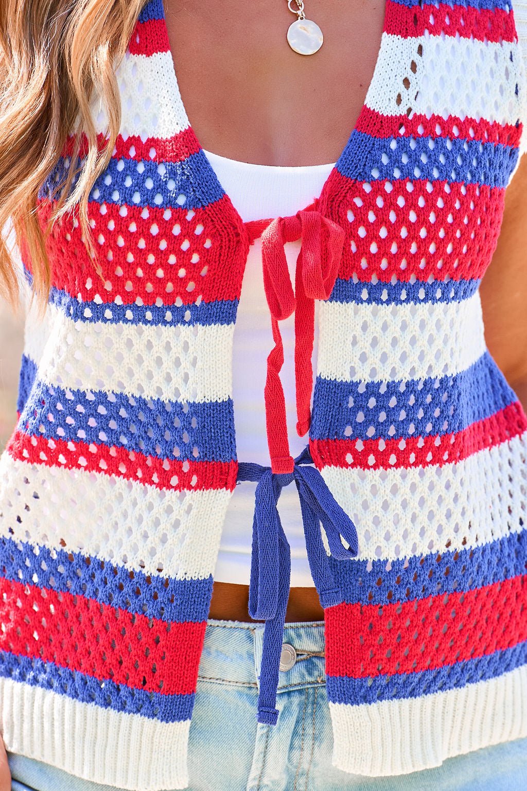 Model in Stars & Stripes Tie Front Sweater Vest over white tank and light blue jeans.