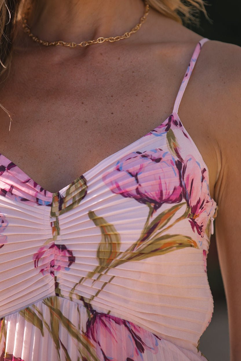 Close-up of a person in the Steve Madden Ray Pink Floral Midi Dress, accessorized with a delicate gold chain necklace.