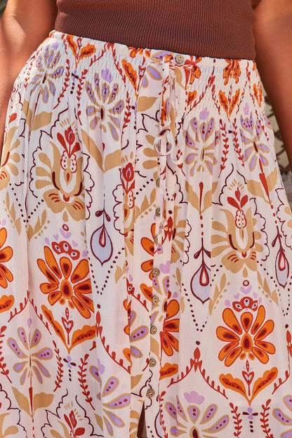 Close-up of the Tropical Treasure Print Maxi Skirt in cream, featuring a floral pattern, paired with a brown top.
