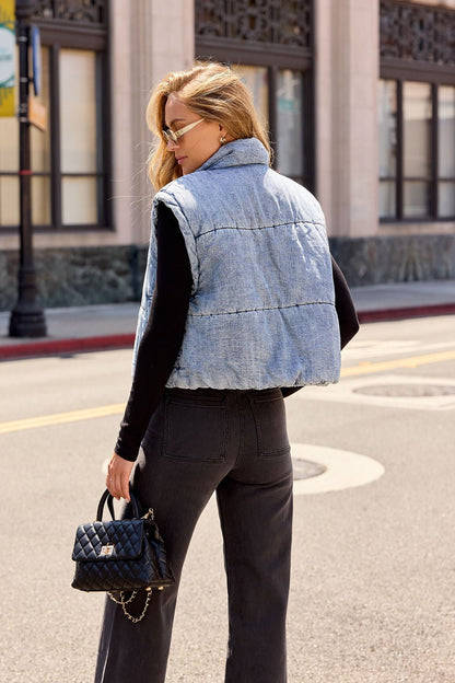 Woman in a Vintage Havana Puffer Vest - Denim, black top, and jeans styles chic fall layers with a black handbag on a city street.